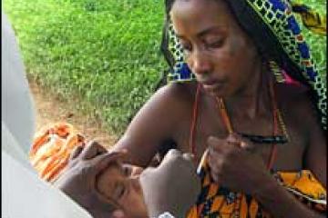 Aisha receiving oral polio vaccine at Shanga