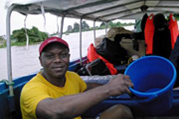 Daniel Umeh draining water from the boat after a downpour