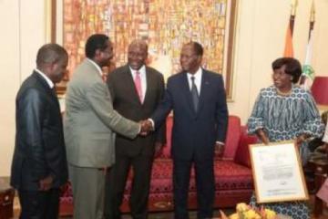 Le président Ouattara salue le Représentant de l’OMS sous le regard du Premier Ministre Kablan Duncan, de la Ministre de la santé, Raymonde Goudou Coffie, et du Directeur du programme de lutte contre le ver de Guinée (premier à partir de la gauche).