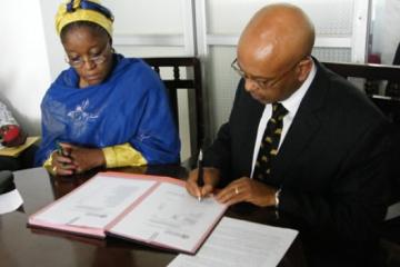 Hon Minister (left) and the WHO Representative signing document