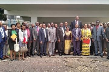 Photo de famille comprenant le Représentant de l’OMS en RDC, le Secrétaire général à la Santé Publique, l’ancien Basketteur de la NBA, Mutombo DIKEMBE et les autres participants à la réunion conjointe sur la lutte contre le cancer du col de l’utérus en RDC, devant la salle de conférence de l’OMS, à Kinshasa