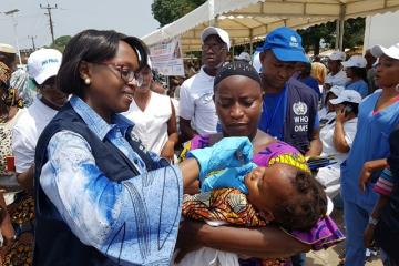 Dubreka La Directrice régionale de l'OMS vaccinant un enfant contre la Polio