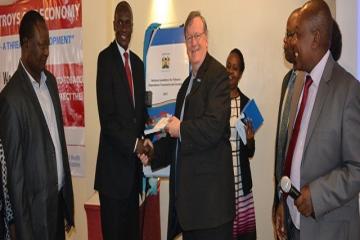 WR Kenya Dr Rudi Eggers receives a copy of the National guidelines for Tobacco Dependence Treatment & Cessation from Dr Patrick Amoth, MOH, while others look on