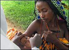 Aisha receiving oral polio vaccine at Shanga