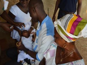  A proud father holding his baby whiles the infant receives Oral Polio Vaccine (OPV)