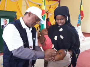 WHO Colleague vaccinating a child during the launching of mOPV2 vaccination