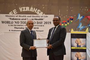 Dr Hon Anwar Husnoo, Minister of Health and Quality of Life receiving the ‘Certificate of Appreciation’ from Dr Laurent Musango, WHO Representative in Mauritius on behalf of Dr Tedros, Director General and Dr Moeti, Regional Director of the World Health Organization during the celebration of the World No-Tobacco Day 2019