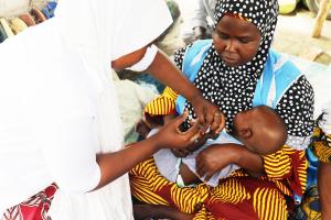 An eligble baby being immunized by Transit team in Muna Market, Maiduguri
