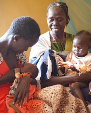 With Bakhita on her lap, Tereza encourages Ajonga to breastfeed her granddaughter, baby Akot.
