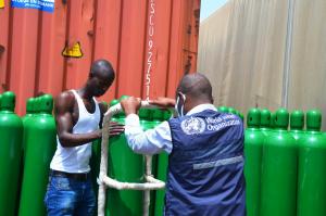 WHO staff supervising the offloading of oxygen cylinders at the Ministry of Health 