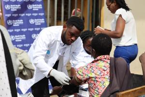 A MEDSAR student checking a woman's blood pressure at the Nyabahinga Market