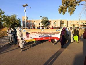 Les participants à la marche de santé tenant une banderole dans une rue de Maradi 