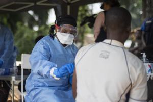 A member of the ring vaccination team vaccinates a man in Bosolo village.