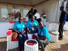 WHO staff enjoy the comfort of a chair made using ARV bottles by one of the partners at the WHO/UNAIDS stall