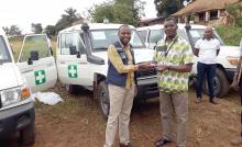 Dr Michel Yao, Incident Manager de l'OMS pour Ebola dans le Nord Kivu remettant officiellement les ambulances au Directeur général de la DGLM du Ministère de la Santé pour la riposte d'Ebola à Beni. OMS/Koné Souleymane