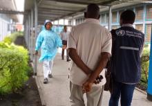 Dr. Ramses Kalumbi walks with the father of a suspected case