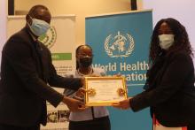 Dr Morrison Sinvula (MoHW) and Dr Joesephine Namboze (WHO Rep) handing over the award to Professor Bontle Mbongwe