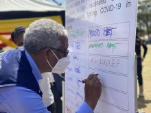 WHO Representative in Uganda Dr Yonas appends his signature on the commitment board as a commitment advocating for COVID-19 vaccination ©WHOUganda