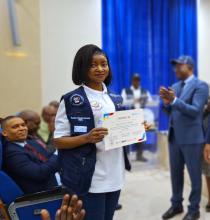 Une des 200 experts et membre du corps des volontaires de santé brandit fièrement son certificat au cours de la cérémonie