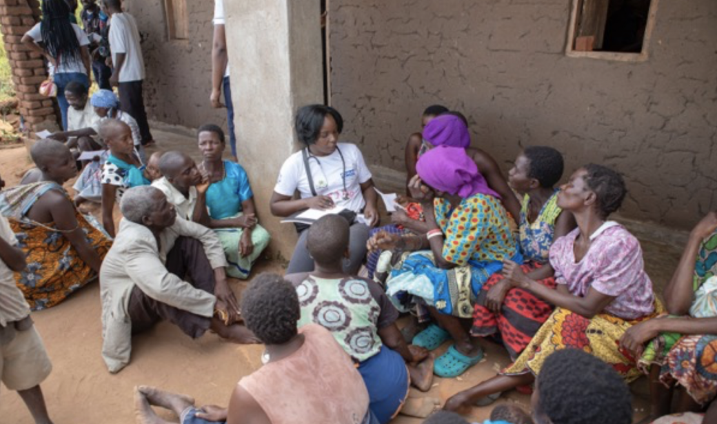At the Maluwa camp health outreach clinic, a doctor attends to the many clients waiting.